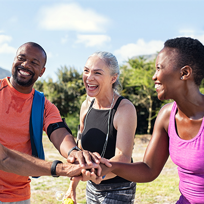 A group of people holding hands and laughing in an open space