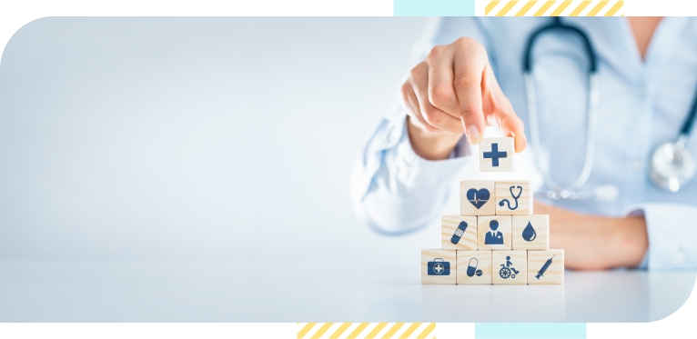 A doctor stacking wooden pieces with medical icons printed on it depicting health technology concept.