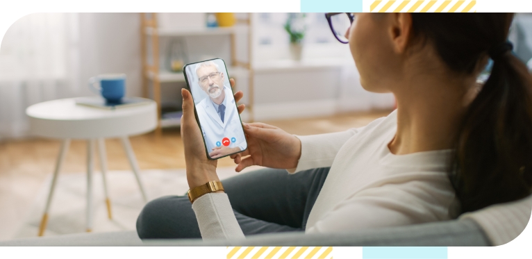 A modern woman sits in a relaxed environment in her home and teleconsults with her doctor via mobile device