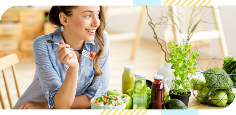 A happy woman having a bowl full of healthy salad.