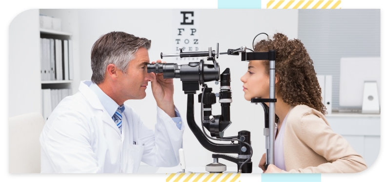 A young woman with her eyes examined by an ophthalmologist with an optical microscope