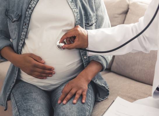 A doctor investigating a pregnant woman.